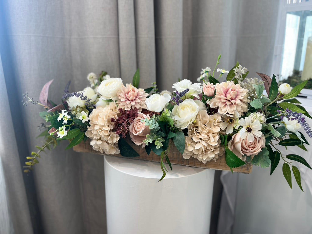 Elongated blush toned silk florals in a greying wooden style container